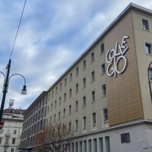 A photo of a long five story building with “collegio” written in large letters.