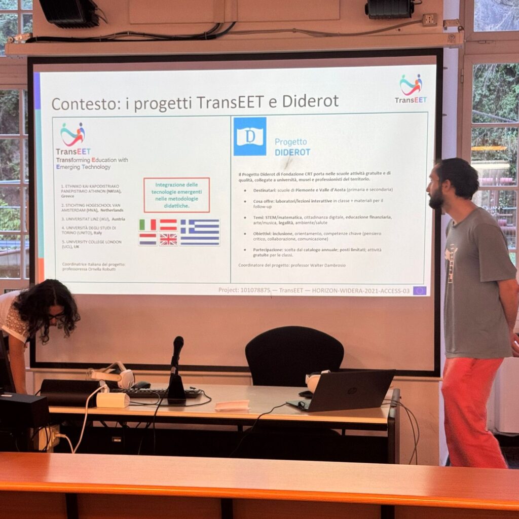 Beatrice Bruno Franco, on the left, while Mosè Colangelo stands on the right. They are presenting the TranSEET Project and Diderot project to the participants with the support of a slide showing the project logos and information about them.